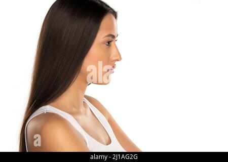 Profil einer jungen Frau mit langen schwarzen Haaren auf weißem Hintergrund Stockfoto