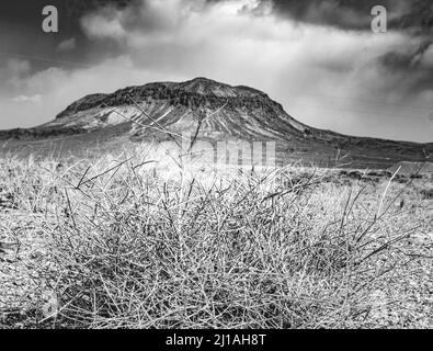 Eine Graustufenaufnahme eines hohen Berges an einem düsteren Tag Stockfoto