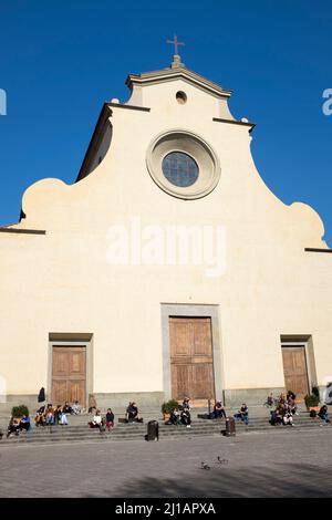 Menschen sitzen in Sonnenschein auf den Stufen der Santo Spirito Kirche Oltarno Florenz Italien Stockfoto