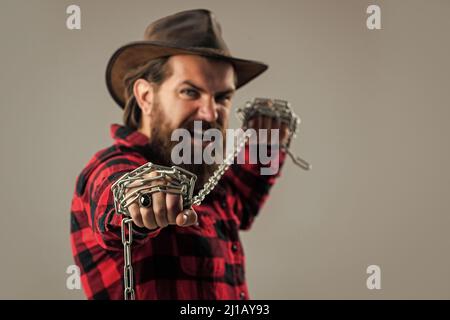 Cowboy mit Bart und Schnurrbart Stahlkette ziehen, Platz kopieren, einfangen Stockfoto