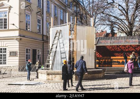 LVIV, UKRAINE - 17. März 2022: Abdeckung der Statue mit einem Schutzschild, um Schäden während eines möglichen Bombardements in Lviv Stadt zu verhindern. Rynok-Platz Stockfoto