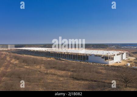 Große Ebene, Baustelle, Bau einer großen Industriehalle. Blick von der Drohne. Stockfoto