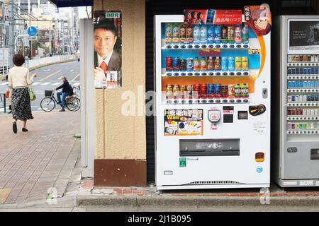 TOKIO, JAPAN - 17. März 2022: Zwei Automaten, einer mit Getränken, der andere mit Zigaretten, in einer Straße im Tokioter Koto ward. Stockfoto