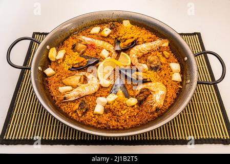 Valencianische Paella mit Meeresfrüchten und goldenem Reis in einer Paella-Pfanne Stockfoto