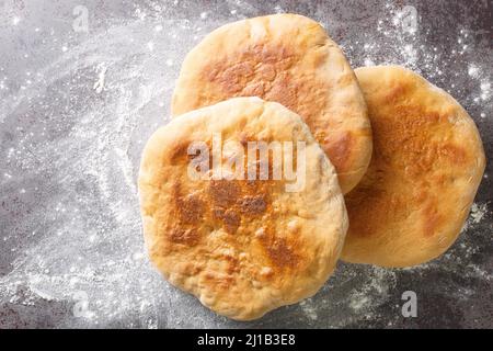 Palyanitsa ist ukrainisches Brot, das auf der Basis von Weizenmehl und Milch in der Nähe auf dem Tisch hergestellt wird. Horizontale Draufsicht von oben Stockfoto