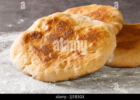 Palyanitsa ist ukrainisches Brot, das auf der Basis von Weizenmehl und Milch in der Nähe auf dem Tisch hergestellt wird. Horizontal Stockfoto