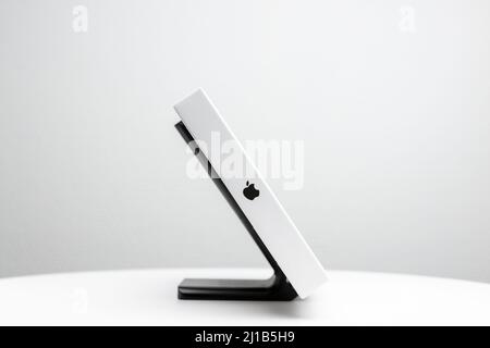Schwarzer Display-Ständer mit Apple-Logo, das auf der Seite weiße Verpackung des Mac Apple Magic Trackpad zeigt. Stockfoto
