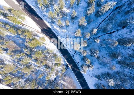 Drohnenfotografie eines Gebirgspasses namens Poetschenpass bei dem österreichischen Dorf Bad Goisern der Dachsteinberg im Hintergrund. Winter moun Stockfoto