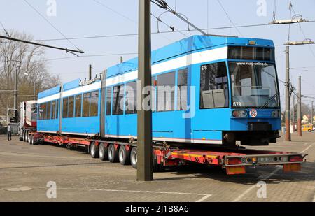 Rostock, Deutschland. 24. März 2022. Im Hof der Rostocker Straßenbahn AG steht am Abend eine 30 Meter lange Straßenbahn auf einem Tieflader bereit zum Ausbau. Die Straßenbahn wird von der Leipziger IFTEC GmbH & Co KG saniert. Insgesamt zehn Straßenbahnen des Typs 6N1, die seit mehr als 25 Jahren im Einsatz sind, sollen in Leipzig erneuert werden. Zusätzlich sollen 28 neue Straßenbahnen gekauft werden. Quelle: Bernd Wüstneck/dpa-Zentralbild/ZB/dpa/Alamy Live News Stockfoto