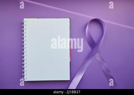 Notizblock und violettes Band zum Purple Day - Welt-Epilepsietag, März 26. Symbol des Epilepsietages. Stockfoto