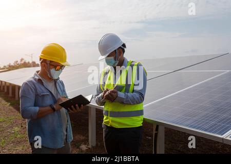 Ingenieure und Techniker arbeiten an der Planung der Stromversorgung von Solarpanel-erneuerbaren Kraftwerken. Stockfoto