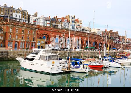 Die Boote sind in Royal Harbour Marina, Ramsgate, Kent, England, vertäut. Military Road und Royal Parade Mauerwerk im Blick Stockfoto