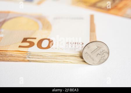 Münze ein Rubel und die europäische Währung: Banknoten von fünfzig Euro-Münzen. Konzept Stockfoto