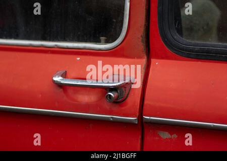 Grauer Metallgriff an der Tür eines alten Autos Stockfoto