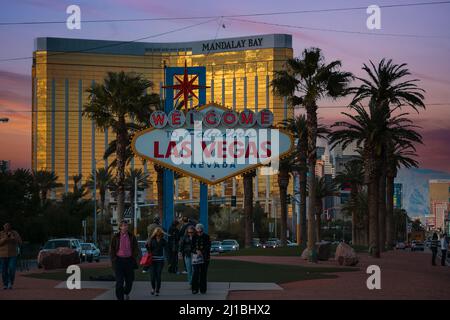 Las Vegas, Nevada, USA, März 2010 - Blick auf das goldfarbene Mandalay Hotel in der Abenddämmerung hinter dem berühmten Vegas Begrüßungsschild Stockfoto