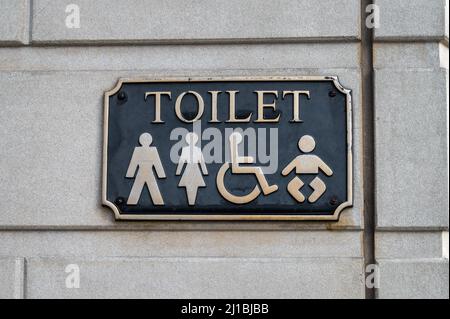 Schild für öffentliche Toiletten mit einem simble eines Mannes, einer Frau, eines Babys und einer behinderten Person Stockfoto