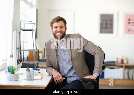 Selbstbewusst und kreativ. Porträt eines gutaussehenden Geschäftsmannes, der in seinem Büro arbeitet. Stockfoto