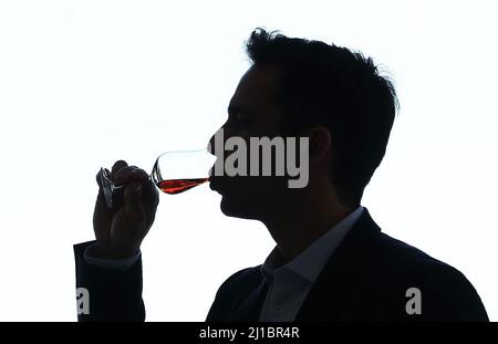 Cognac, Frankreich. 22. März 2022. Ein Mann schmeckt ein Glas Cognac im Hennessy-Haus in Cognac, Südwestfrankreich, 22. März 2022. Cognac/Eau-de-vie de Cognac/Eau-de-vie des charentes ist im Abkommen zwischen China und der EU über geografische Angaben aufgeführt. Kredit: Gao Jing/Xinhua/Alamy Live Nachrichten Stockfoto