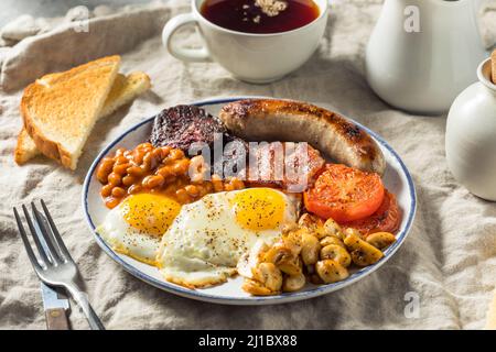 Hausgemachtes englisches Frühstück mit Eiern, Wurst, Schinken und Bohnen Stockfoto