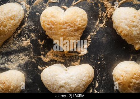 Blätterteig herzförmige Plätzchen auf Backblech, Draufsicht. Backen Valentinstag hausgemachtes Dessert Stockfoto