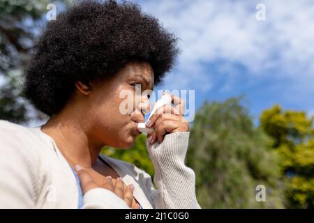 Nahaufnahme einer afroamerikanischen Frau mit mittlerem Erwachsenen und Hand auf der Brust mit Asthma-Inhalator Stockfoto