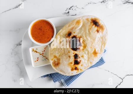 Gemüse-Biryani mit Raita und Sauce in einem Gericht isoliert auf Serviette Seitenansicht auf grauem Hintergrund berühmte indische und pakistanische Küche Stockfoto