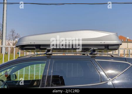 Große silberne Dachkiste bei Black SUV Stockfoto