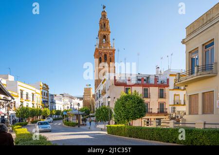 Die Hauptstraße durch Carmona, Spanien, mit der Puerta de Sevilla Alcazar und der Kirche San Pedro in der Ferne. Stockfoto