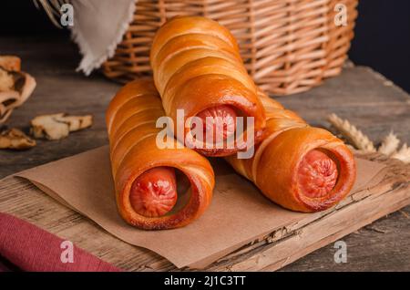 Appetitlich frisches kulinarisches Gebäck - Würste in Gebäck auf Holz Hintergrund Stockfoto