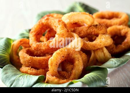 Gebratene Tintenfischringe mit Zitrone auf einem Teller paniert Stockfoto