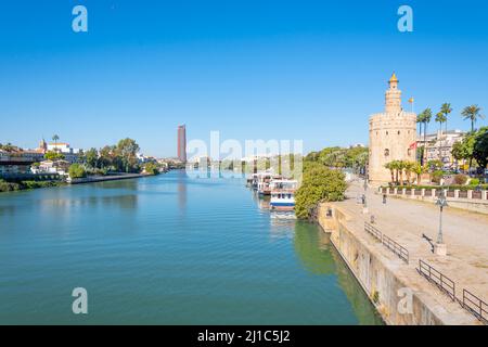 Der Guadalquivier, der durch das historische Zentrum von Sevilla, Spanien, fließt, mit dem Triana-Viertel und dem Torre del Oro-Wachturm im Blick. Stockfoto