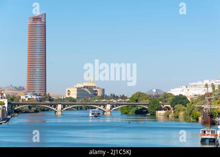 Der Guadalquivier fließt durch das historische Zentrum von Sevilla, Spanien, mit Blick auf den modernen Sevilla-Turm. Stockfoto