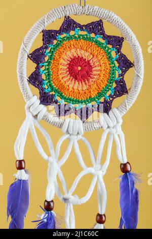 Amulett Dreamcatcher auf einem gelben Hintergrund Nahaufnahme Schutz der Schläfer vor bösen Geistern und Krankheiten Stockfoto