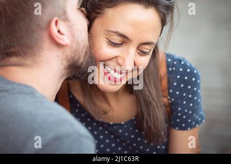Nahaufnahme eines glücklichen Paares, das im Freien zusammen sitzt Stockfoto
