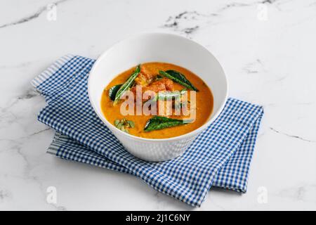 Goan Fish Curry Masala in einem Gericht isoliert auf Serviette Seitenansicht auf grauem Hintergrund berühmten indischen und pakistanischen Essen Stockfoto