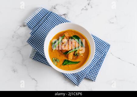 Goan Fish Curry Masala in einem Gericht isoliert auf Serviette Seitenansicht auf grauem Hintergrund berühmten indischen und pakistanischen Essen Stockfoto