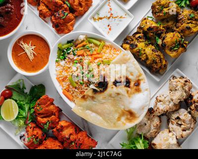 Verschiedene berühmte indische und pakistanische Speisen Tisch Gemüse Biryani, Butter Chicken, Paneer Chicken Tikka Boti Kebab, Limette, Kali Mirchi, Tomatensauce, r Stockfoto