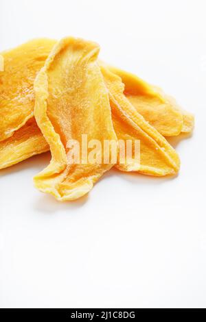 Orangefarbene Scheiben getrockneter Zucker-Mango isoliert auf weißem Hintergrund Stockfoto