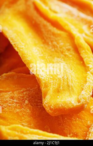 Süße getrocknete Mango-Stücke aus der Nähe als Hintergrund in der Vollbildansicht von oben Stockfoto