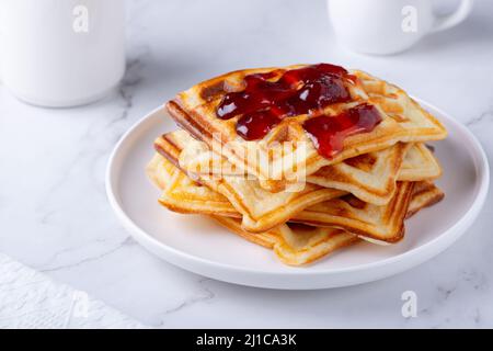 Hausgemachte leckere belgische Waffeln auf dem weißen Tisch Stockfoto