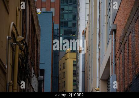 Blick nach oben auf die Gasse, in der Gebäude in der Umgebung geschlossen sind. Stockfoto