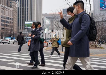 Seoul, Südkorea. 24. März 2022. Menschen mit Gesichtsmasken als vorbeugende Maßnahme gegen die Ausbreitung des Coronavirus überqueren die Straße. (Foto von Simon Shin/SOPA Images/Sipa USA) Quelle: SIPA USA/Alamy Live News Stockfoto