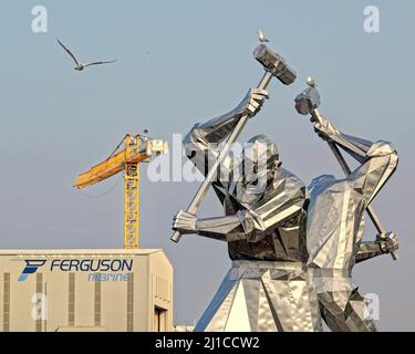 Glasgow, Schottland, Großbritannien 24.. März 2022. Das Fiasko der Ferguson Ferry geht weiter, da die Schiffe weiterhin umstritten sind, da sie in der Werft im Hafen von Glasgow unter dem ironischen Schatten der riesigen Statue liegen, die eine Hommage an die Fähigkeiten der schottischen Schiffsbauer ist. Die Statue ist 33 Meter hoch und wird Schiffsbauer genannt. Credit Gerard Ferry/Alamy Live News Stockfoto