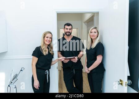 Eine Gruppe von medizinischen Fachleuten in schwarzen Peelings diskutieren einen Fall Stockfoto