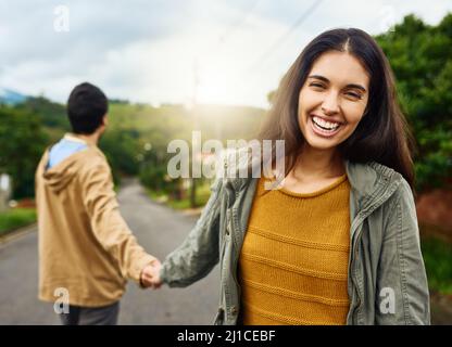 Ich lasse ihn nie gehen. Aufnahme einer schönen jungen Frau, die sich an der Hand ihres Freundes hält. Stockfoto