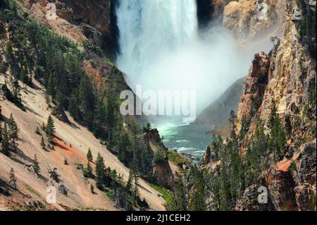 Die erstaunliche Kraft der Lower Falls im Yellowstone National Park wird gezeigt, wenn die donnernde Wasserwand auf die Felsen darunter trifft und ein Wasserstrahl aufsteigt Stockfoto