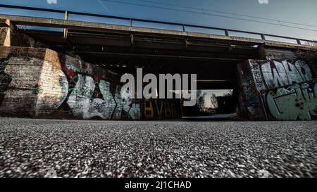 Dortmund, Deutschland - 19. März 2022: Bahnunterführung am ehemaligen Standort Phoenix West. Die Wände sind mit Graffiti besprüht. Stockfoto