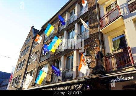 Verschiedene lokale und internationale Flaggen (EU-Flagge, Düsseldorf-Flagge, Ukraine-Flagge) vor einem Restaurant in der Düsseldorfer Altstadt. Stockfoto