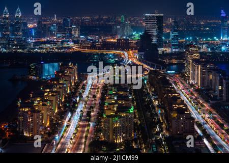 Dubai, VAE – 05 2021. Dez.: Luftaufnahme des Jumeirah Palm Dubai bei Nacht mit langen Lichtstreifen. Tapete mit Blick auf die Stadt bei Nacht in Dubai Stockfoto