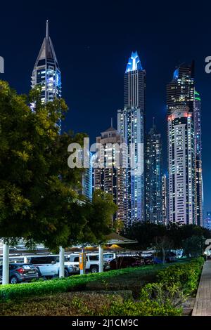 Dubai, VAE - 05 2021. Dez.: Vertikale Ansicht der Wolkenkratzer der Dubai Marina mit Parkwagen vor der Nacht; Tapete mit Stadtbild von Dubai Stockfoto